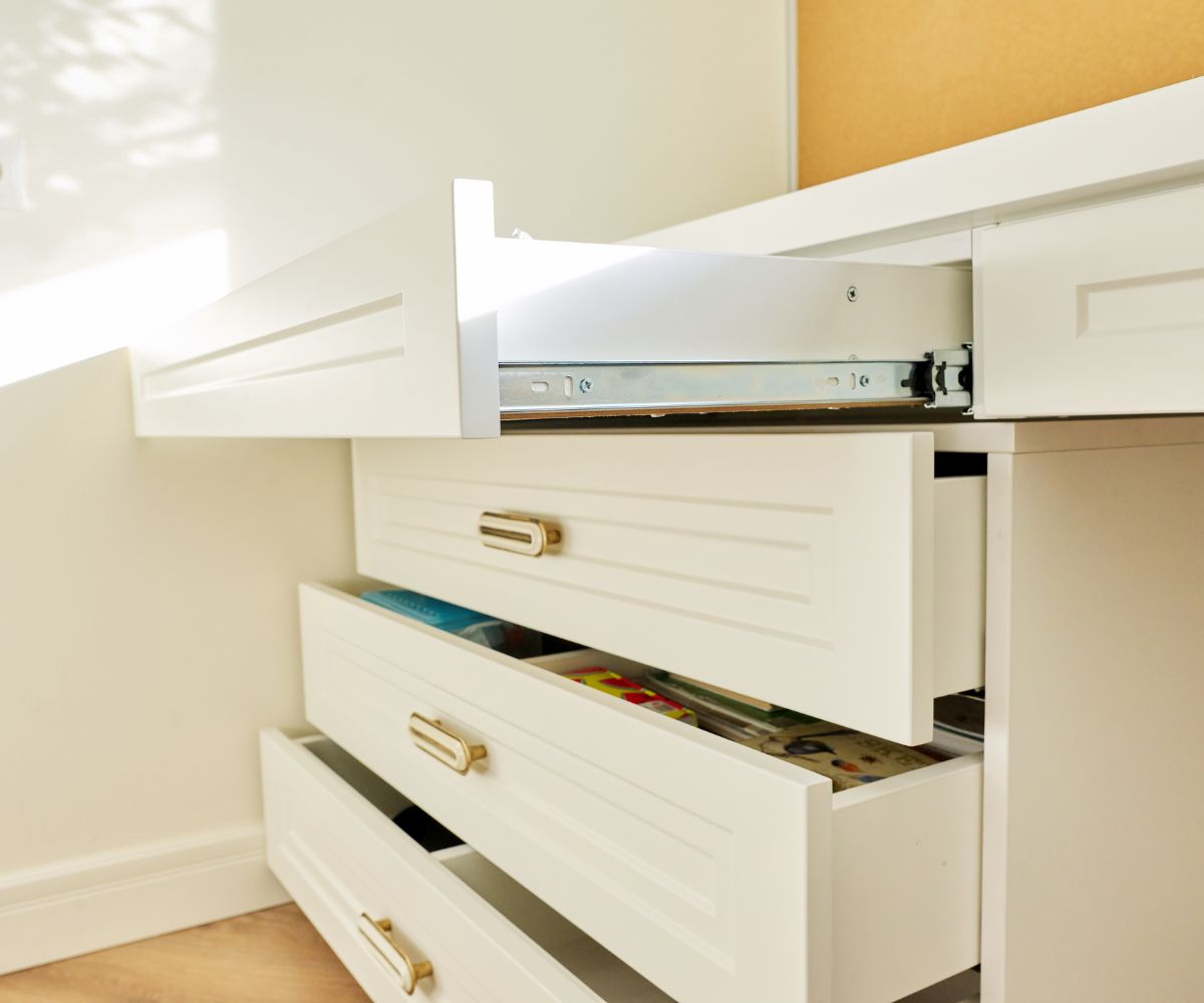 Open white drawers with brass handles.