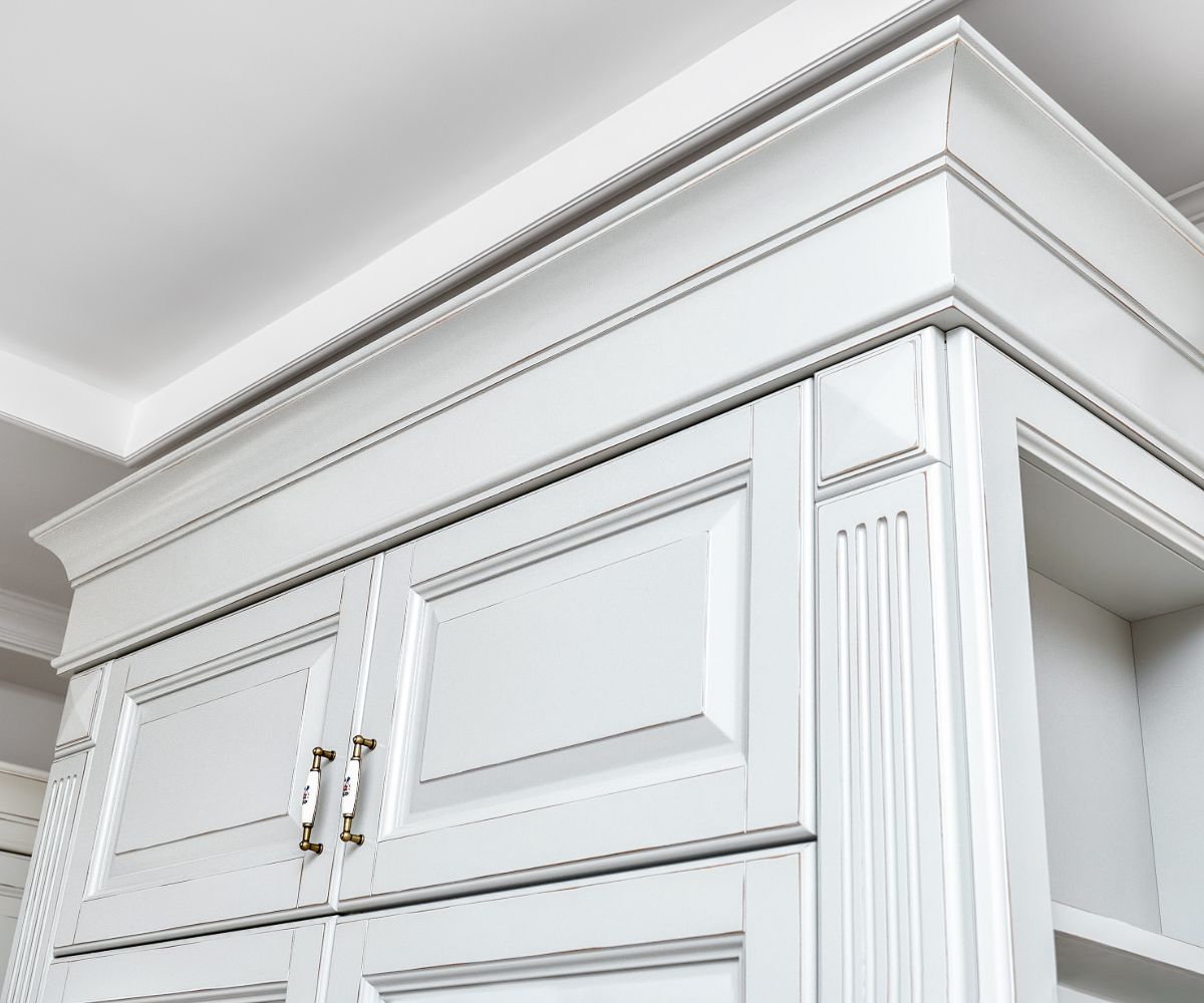 White kitchen cabinet with decorative molding detail.