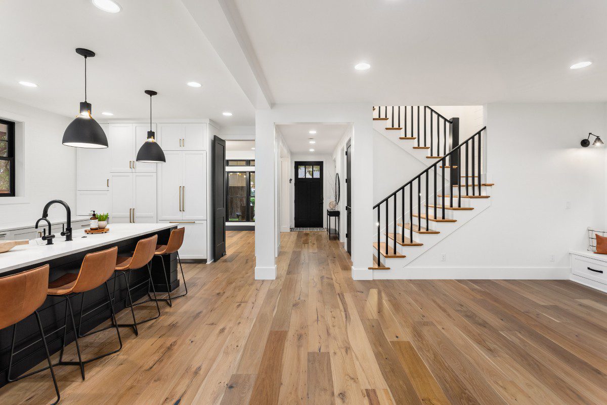 Modern kitchen and living space with staircase.