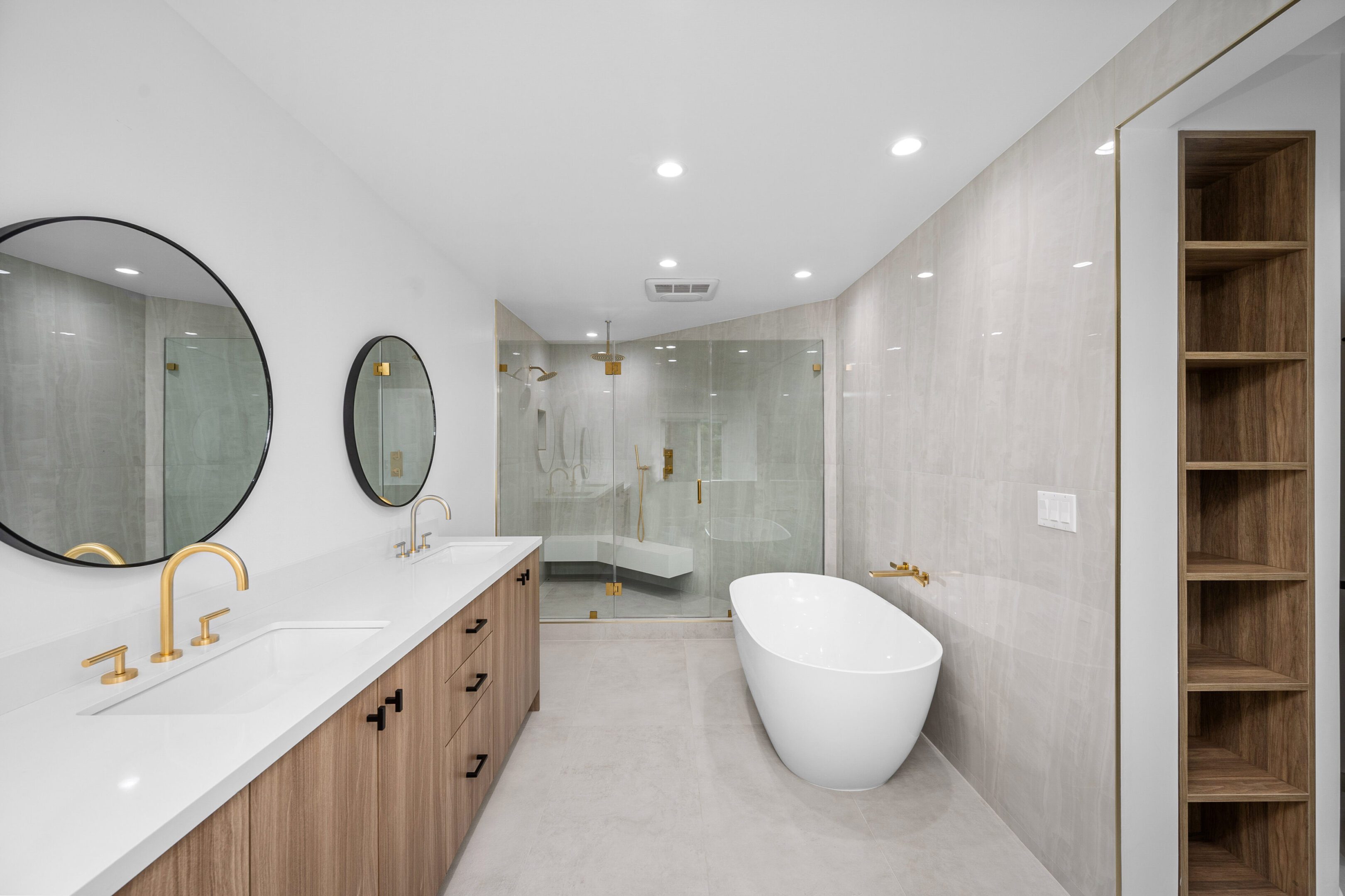 Modern bathroom with bathtub and dual sinks.