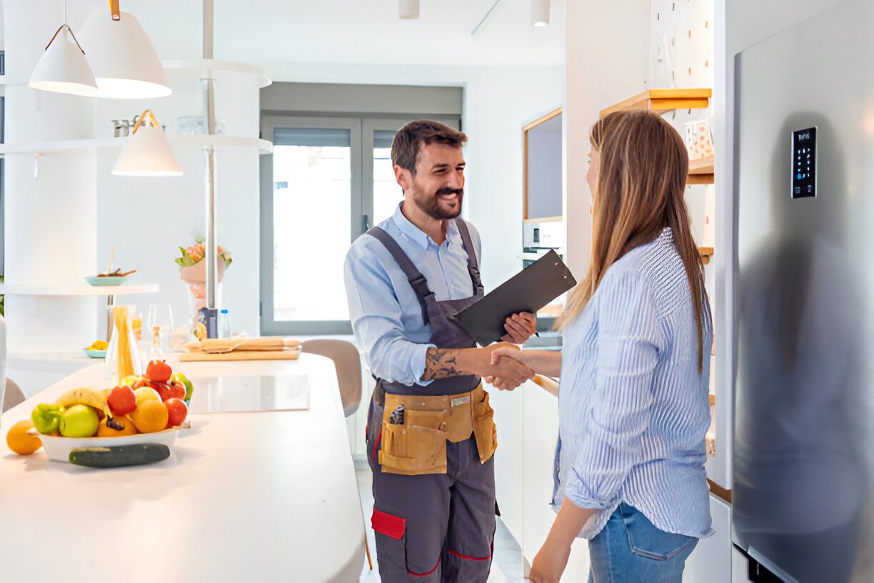 h1-2-ser (1) Handshake between woman and repairman in kitchen.