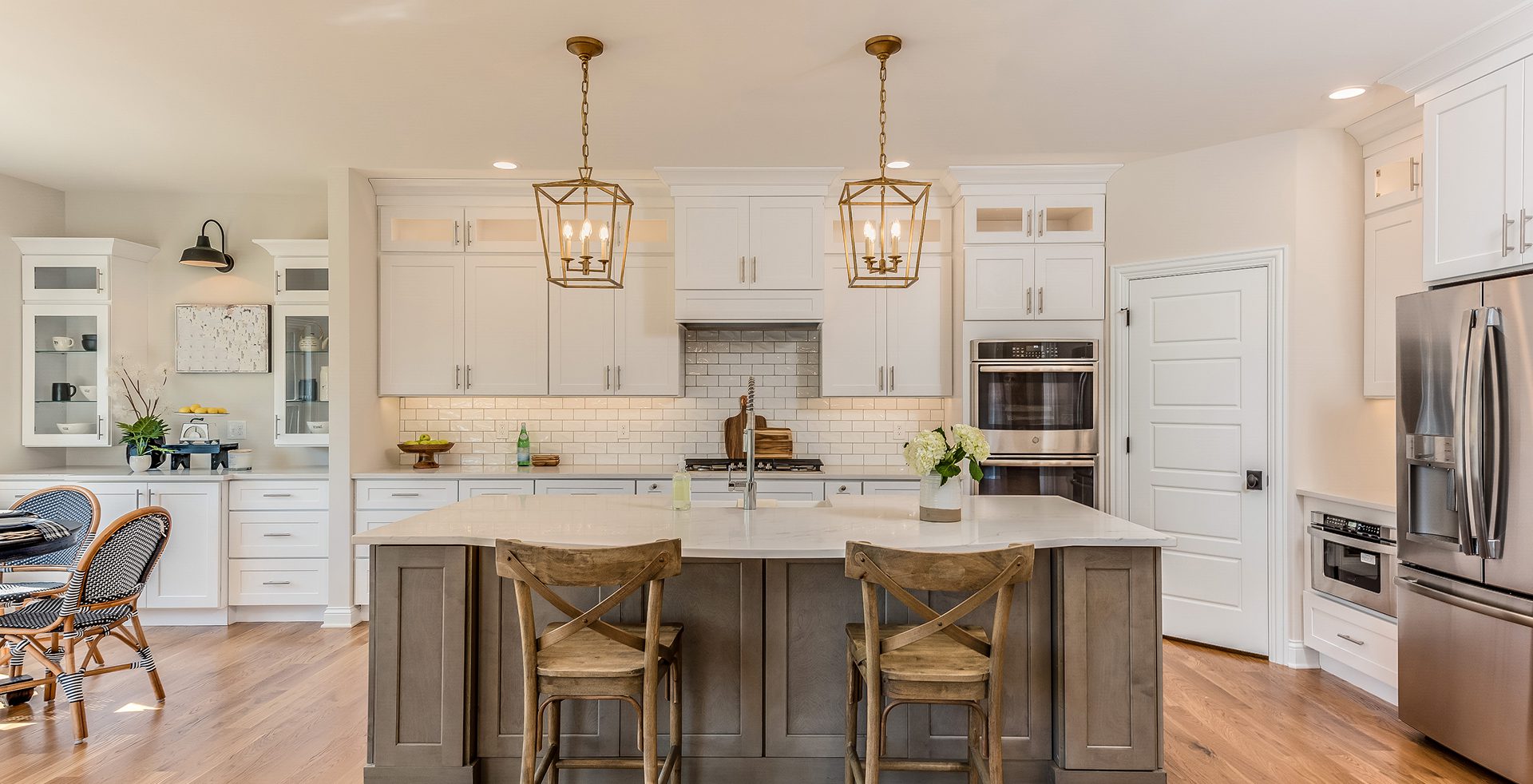 Modern kitchen with island and wooden chairs.