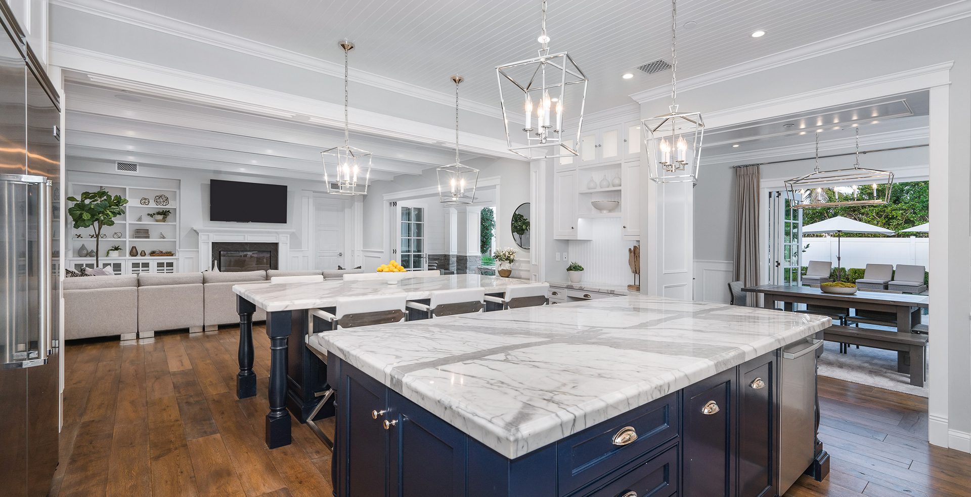 Spacious kitchen with marble countertops and lights.