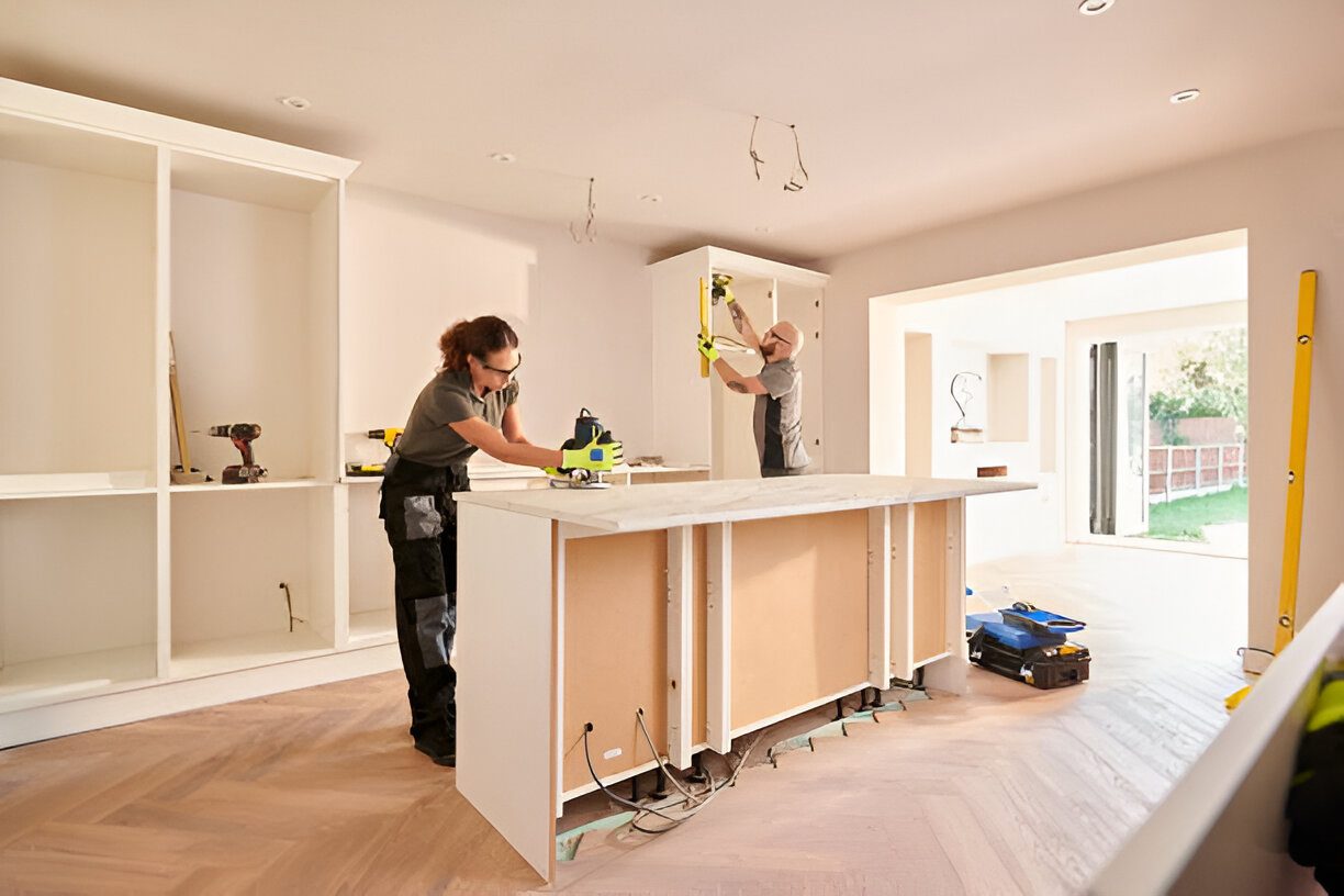 ser-1 (1) Kitchen renovation with two workers installing cabinets.